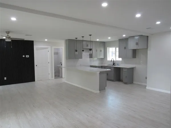 a kitchen with stainless steel appliances kitchen island granite countertop a refrigerator a sink a stove and white cabinets