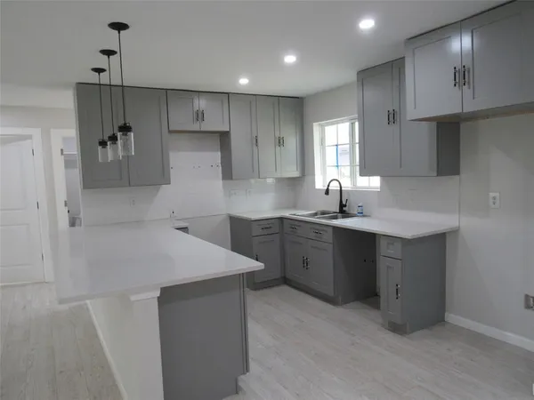 a kitchen with a sink cabinets and wooden floor