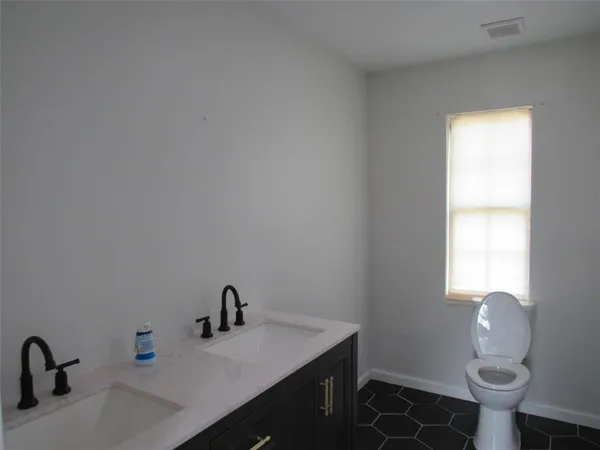 a bathroom with a sink vanity and a toilet