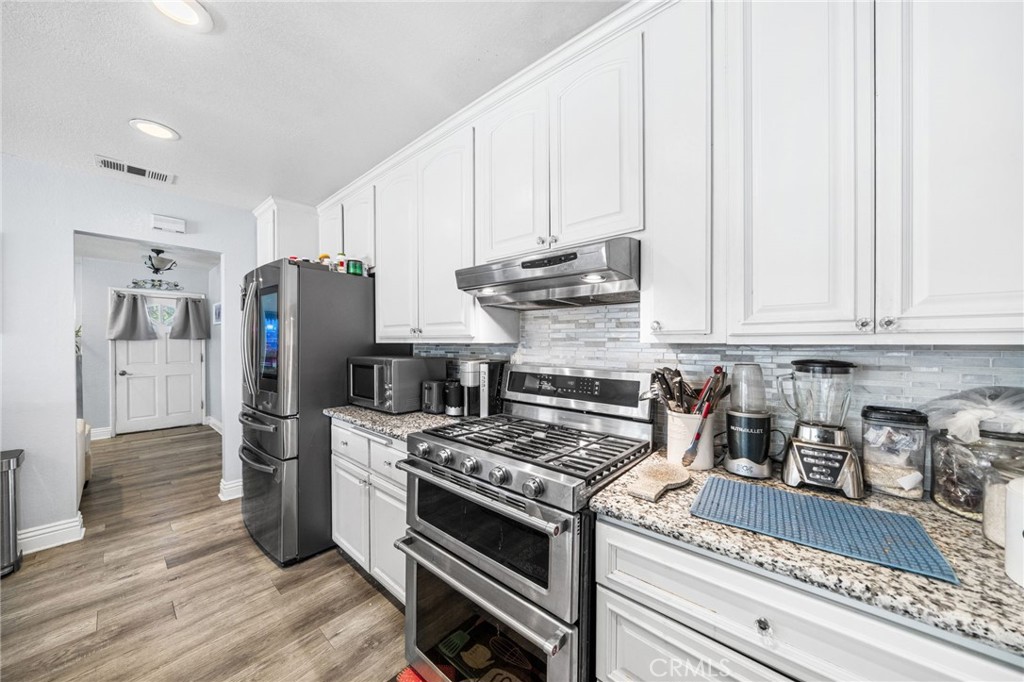 8526 San Vicente Avenue Riverside, CA 92504 - Photo 11 of 30 a kitchen with stainless steel appliances granite countertop a refrigerator stove and sink