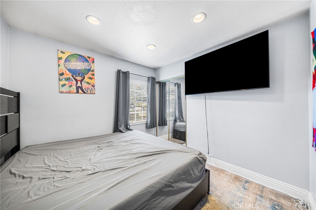8526 San Vicente Avenue Riverside, CA 92504 - Photo 15 of 30 a bedroom with a bed and a flat screen tv