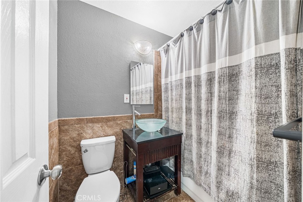 8526 San Vicente Avenue Riverside, CA 92504 - Photo 17 of 30 a bathroom with a granite countertop toilet and a sink