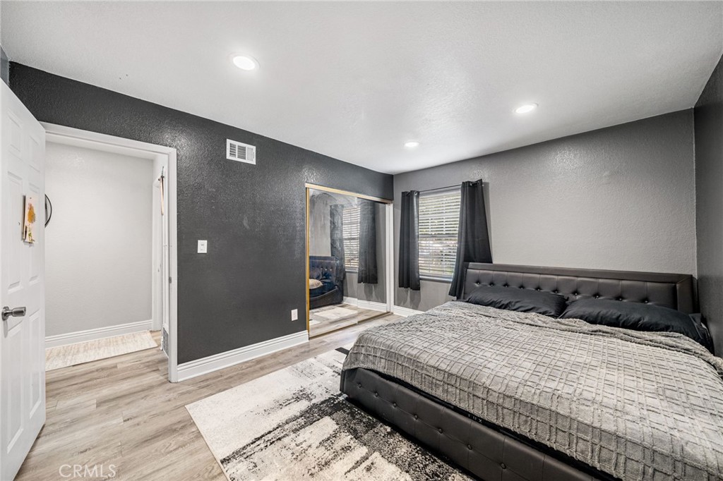 8526 San Vicente Avenue Riverside, CA 92504 - Photo 22 of 30 a bedroom with a large bed and a chandelier