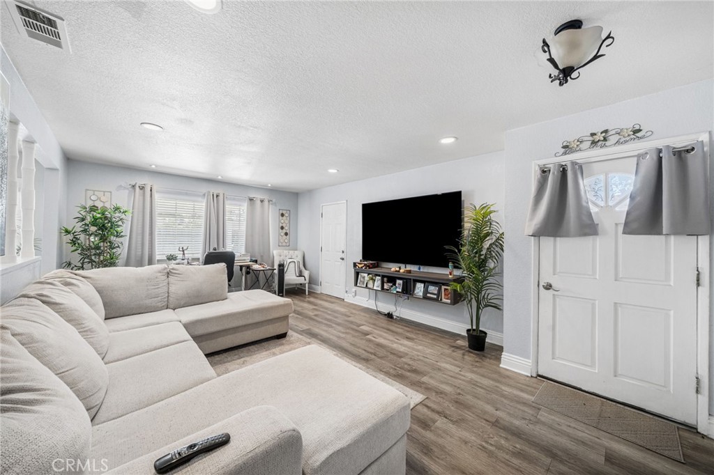 8526 San Vicente Avenue Riverside, CA 92504 - Photo 4 of 30 a living room with furniture and a flat screen tv