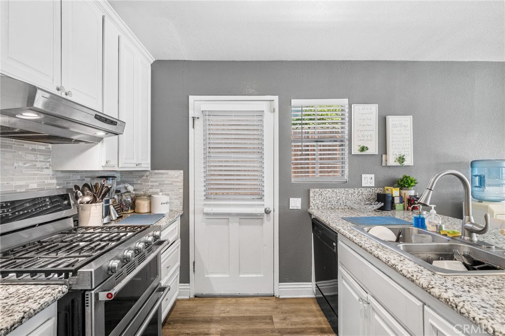 8526 San Vicente Avenue Riverside, CA 92504 - Photo 8 of 30 a kitchen with granite countertop a sink stove and cabinets