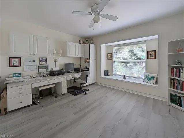 a view of kitchen and workspace with furniture window and wooden floor