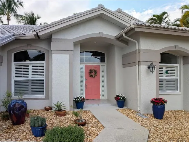 a front view of a house with outdoor seating and a potted plant