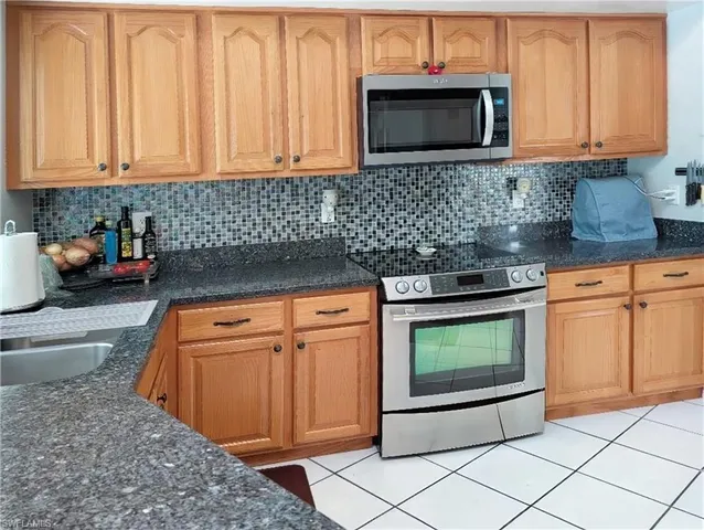 a kitchen with stainless steel appliances granite countertop a stove a microwave and a sink