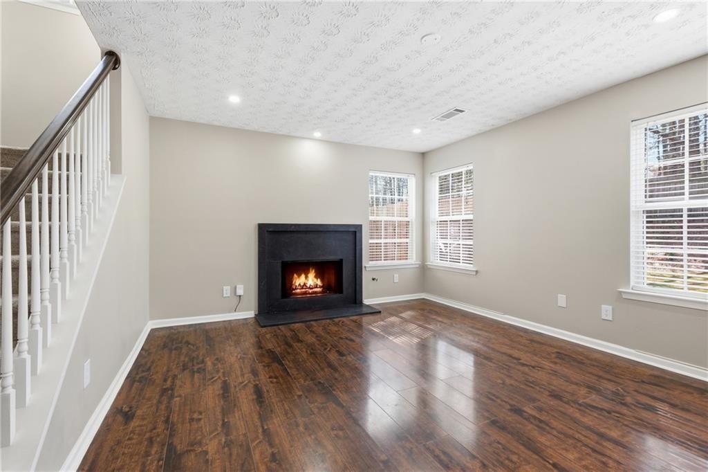 3570 Bogan Mill Road Northeast Buford, GA 30519 - Photo 16 of 31 a view of an empty room with wooden floor fireplace and a window