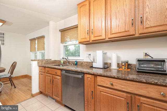 a kitchen with granite countertop stainless steel appliances a sink and a window