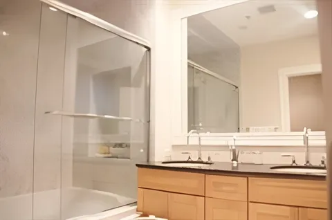 a bathroom with a granite countertop sink mirror and a bathtub