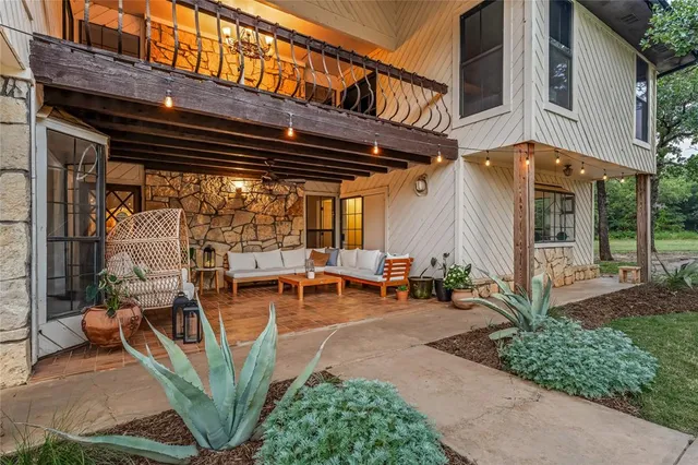 a view of a patio with table and chairs potted plants and floor to ceiling window