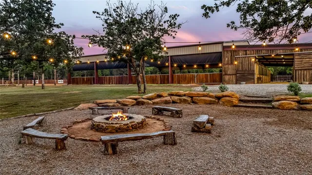 a view of a backyard with table and chairs and a fire pit