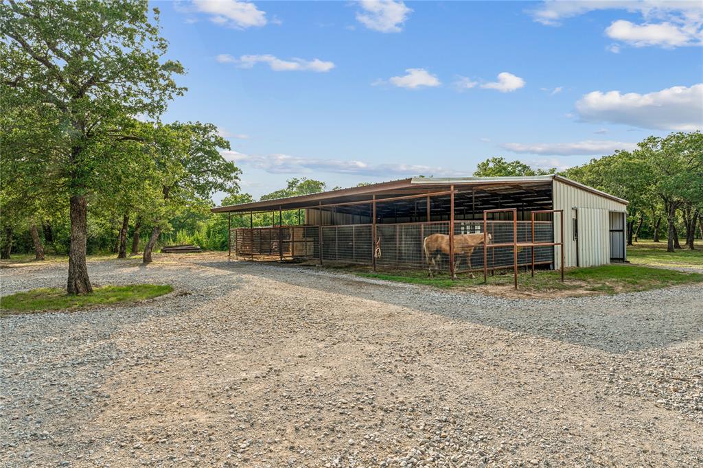 3113 Rock Creek Road Mineral Wells, TX 76067 - Photo 28 of 37 a view of a house with backyard and a tree