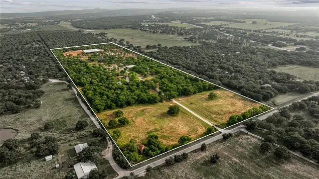 an aerial view of a residential houses with yard
