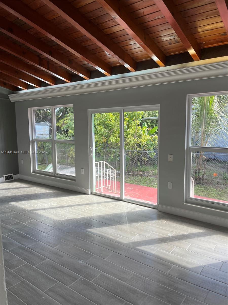 1386 Northwest 38th Street, Unit 1 Miami, FL 33142 - Photo 2 of 8 a view of empty room with wooden floor and fan