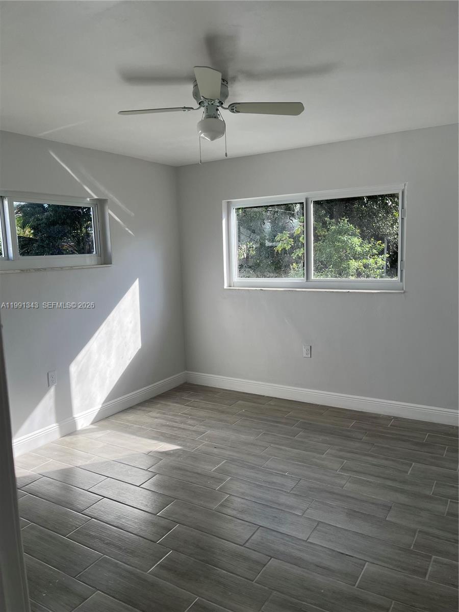 1386 Northwest 38th Street, Unit 1 Miami, FL 33142 - Photo 5 of 8 a view of an empty room with wooden floor and a window