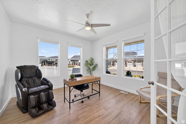 1165 West Union Bench Drive Mapleton, UT 84664 - Photo 7 of 61 Room featuring wood-finish flooring, a contemporary ceiling fan with integrated lighting, and multiple windows with white trim