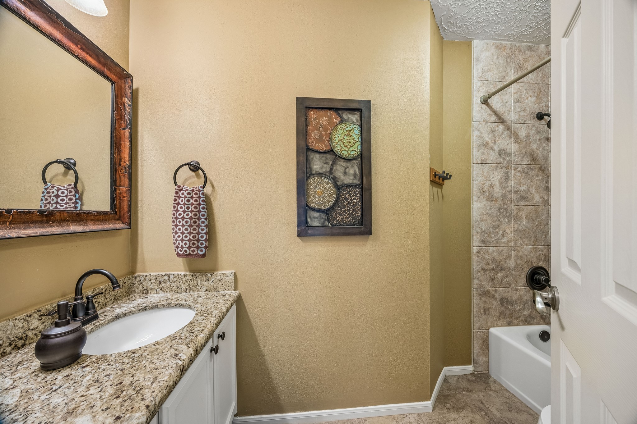 2030 Gemini Street Houston, TX 77058 - Photo 22 of 25 a bathroom with a granite countertop sink a toilet and a mirror