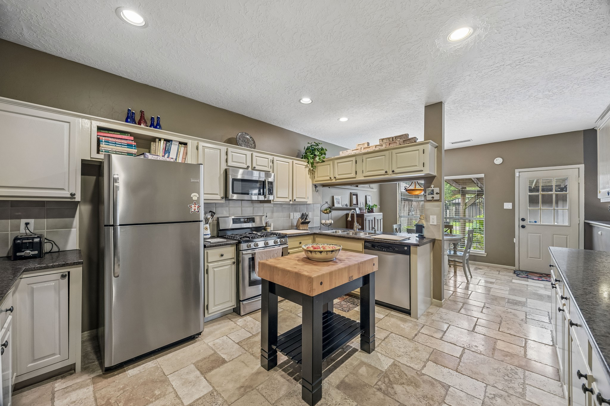 2030 Gemini Street Houston, TX 77058 - Photo 10 of 25 a kitchen with stainless steel appliances granite countertop a refrigerator a stove a sink a dining table and chairs with wooden floor