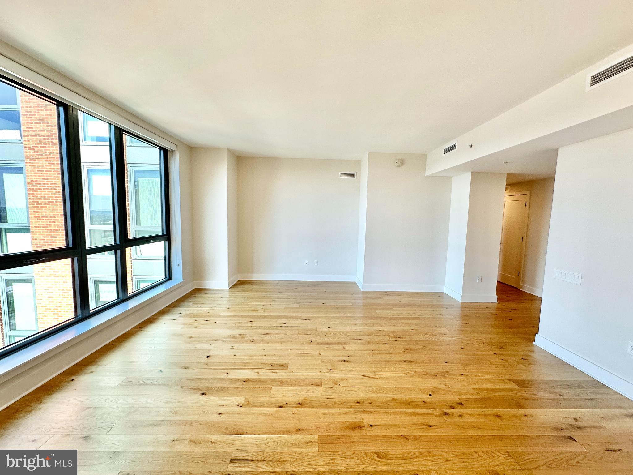 1211 Van Street Southeast, Unit 1201 Washington, DC 20003 - Photo 12 of 60 a view of an empty room with window and wooden floor