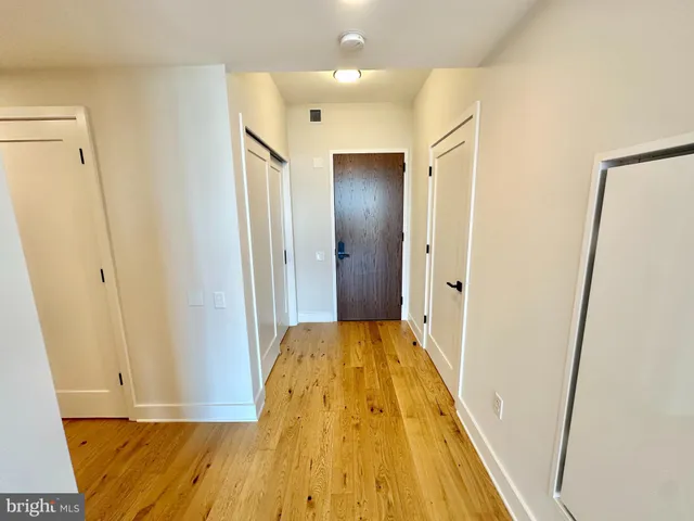 a view of a hallway with wooden floor and staircase