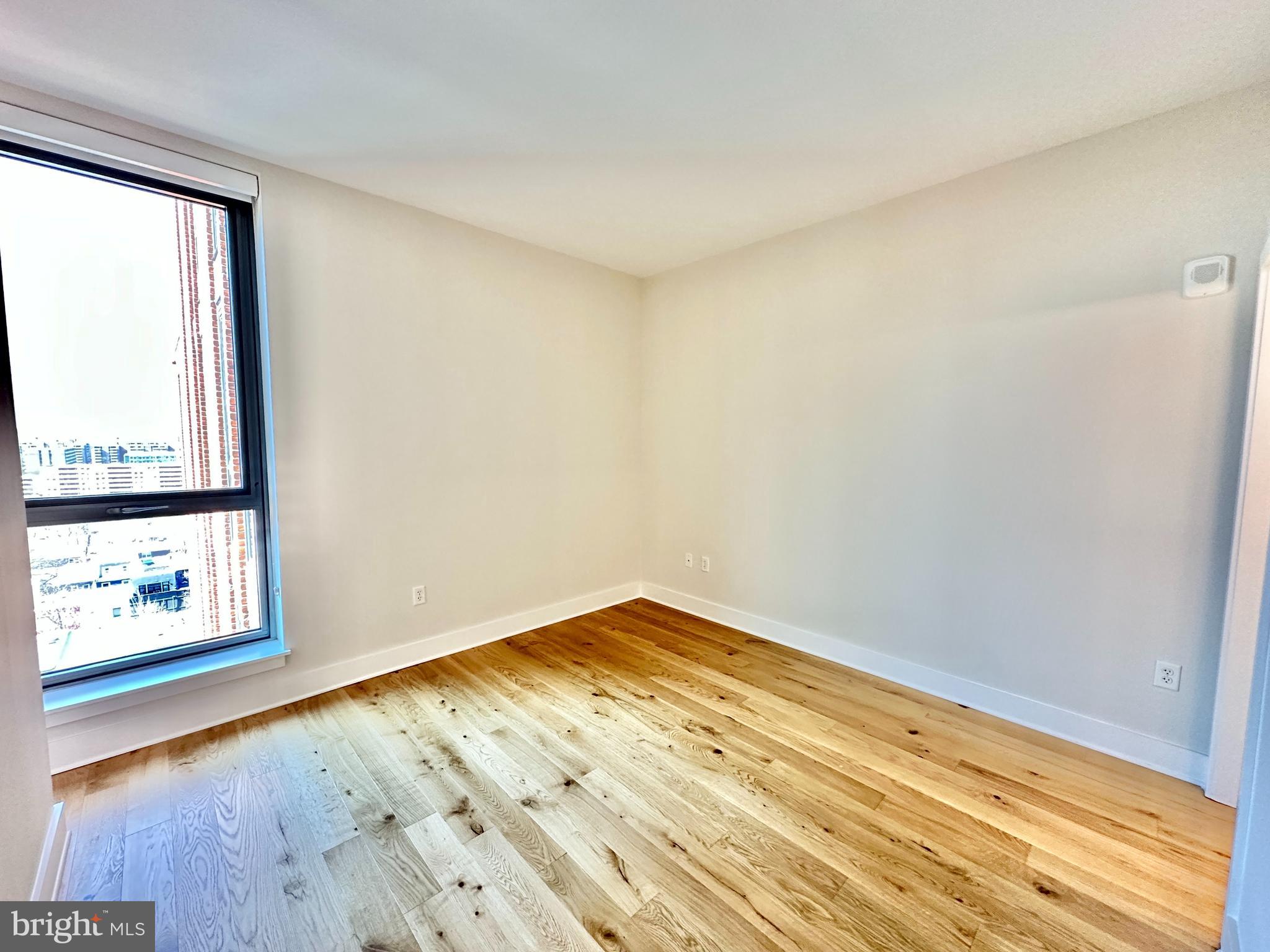 1211 Van Street Southeast, Unit 1201 Washington, DC 20003 - Photo 17 of 60 an empty room with wooden floor and windows