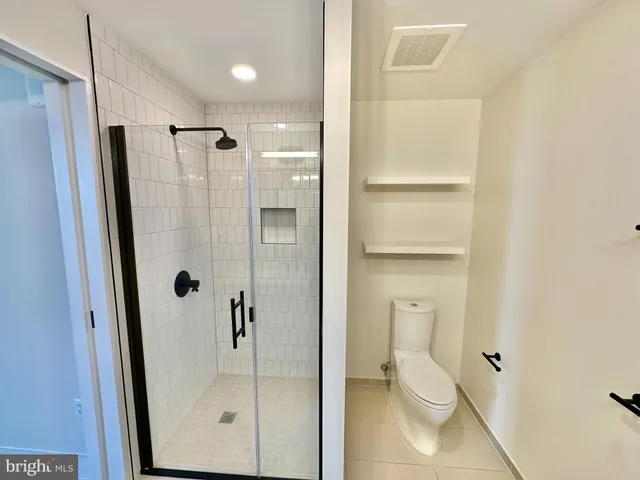 a view of walk in closet with clothes washer and dryer
