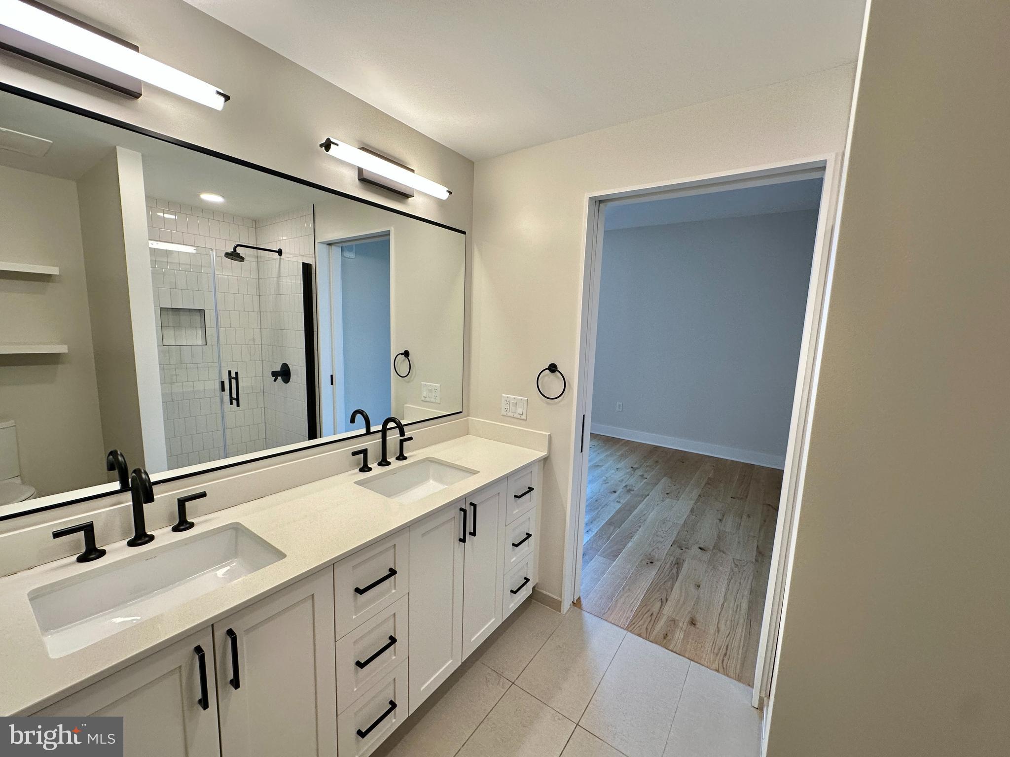 1211 Van Street Southeast, Unit 1201 Washington, DC 20003 - Photo 25 of 60 a bathroom with a double vanity sink and mirror