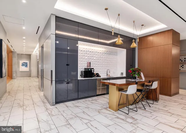 a living room with stainless steel appliances kitchen island granite countertop a sink a counter top space and furniture