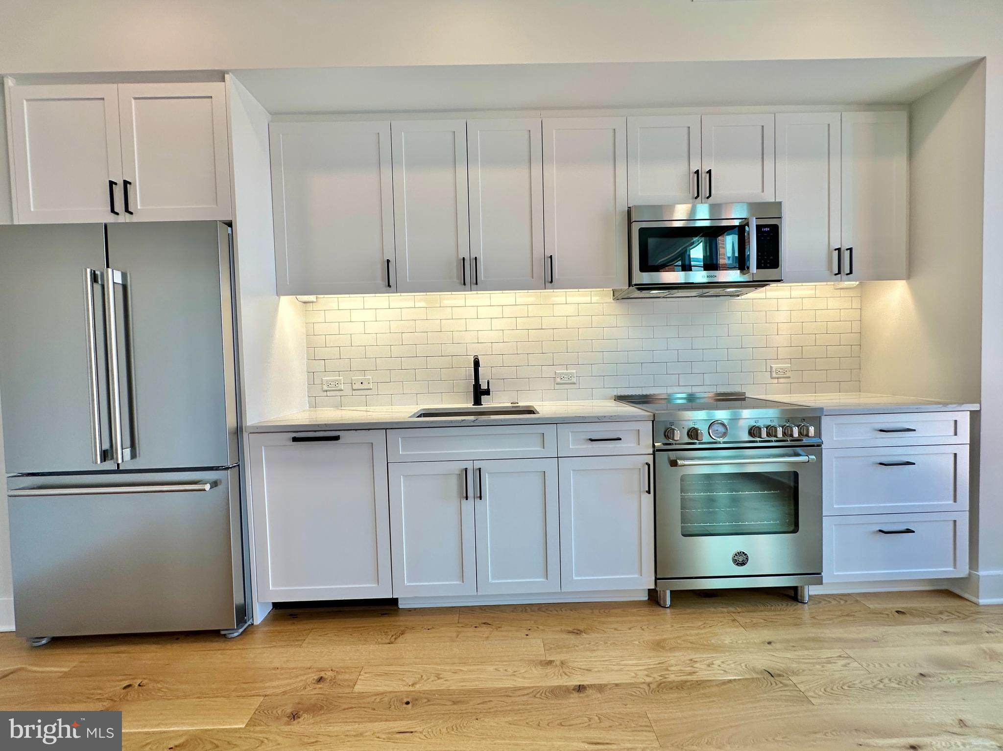 1211 Van Street Southeast, Unit 1201 Washington, DC 20003 - Photo 5 of 60 a kitchen with stainless steel appliances granite countertop a refrigerator a stove a sink and white cabinets