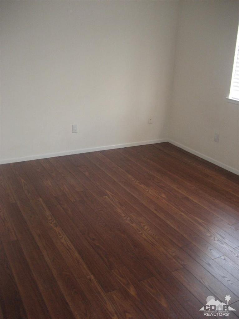 72694 Eagle Road, Unit 3 Palm Desert, CA 92260 - Photo 15 of 35 an empty room with wooden floor