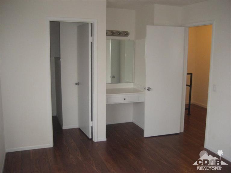 72694 Eagle Road, Unit 3 Palm Desert, CA 92260 - Photo 16 of 35 an empty room with wooden floor and cabinet