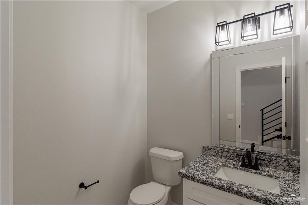 5510 North Crown Point Pharr, TX 78577 - Photo 12 of 14 a bathroom with a granite countertop toilet and a sink