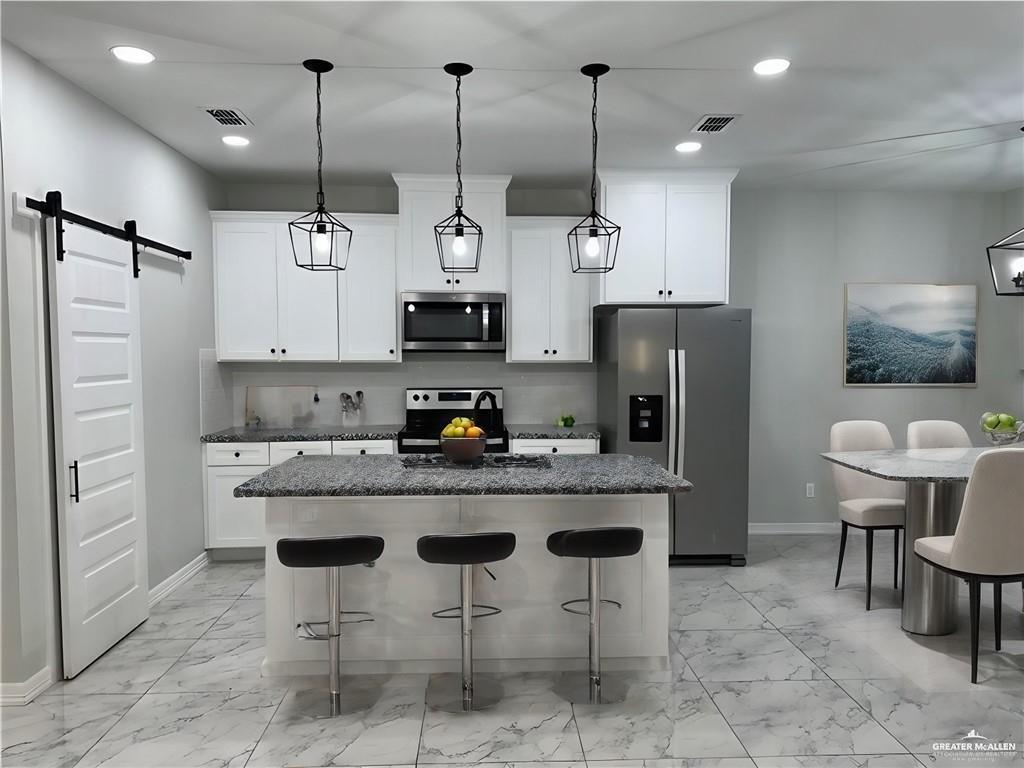 5510 North Crown Point Pharr, TX 78577 - Photo 3 of 14 a kitchen with stainless steel appliances kitchen island granite countertop a refrigerator a stove a sink and a chairs