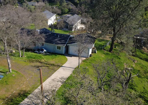 an aerial view of a house with a yard basket ball court and outdoor seating