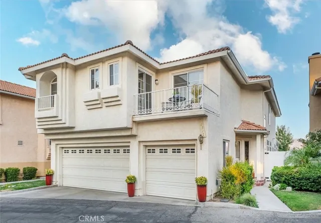 a view of a white house with large windows and plants