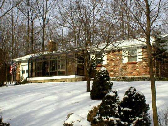 a view of a house with a yard covered with snow in the outdoor space