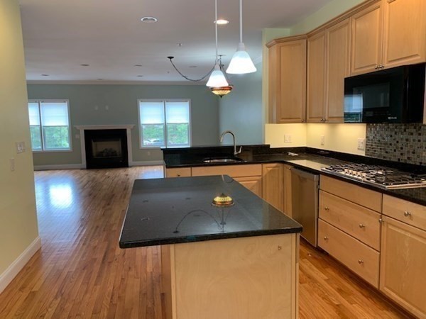 3 Dansereau Place, Unit 3 Middleton, MA 01949 - Photo 15 of 34 a kitchen with granite countertop a sink a counter top space cabinets and stainless steel appliances