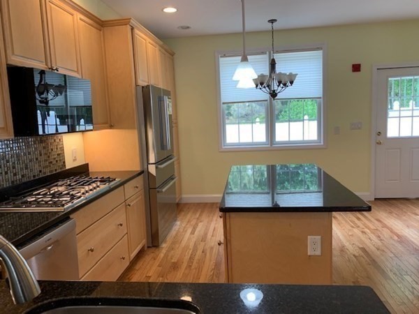 3 Dansereau Place, Unit 3 Middleton, MA 01949 - Photo 17 of 34 a kitchen with stainless steel appliances granite countertop a refrigerator a stove and a sink with wooden floor