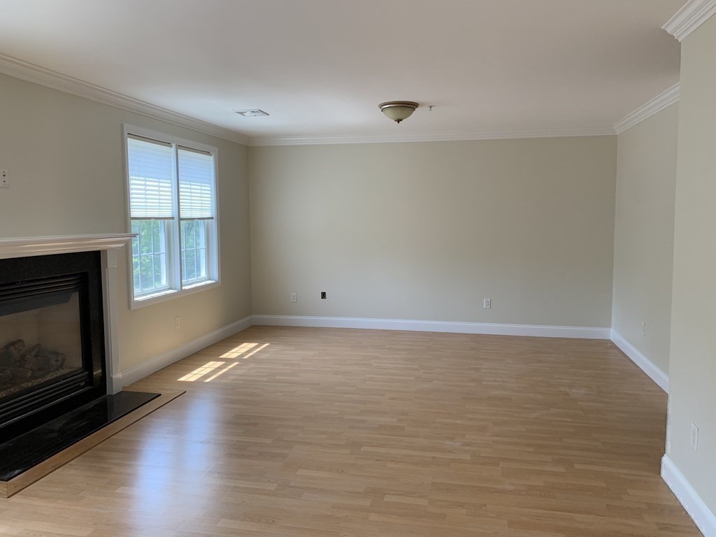 3 Dansereau Place, Unit 3 Middleton, MA 01949 - Photo 26 of 34 a view of an empty room with wooden floor and a window