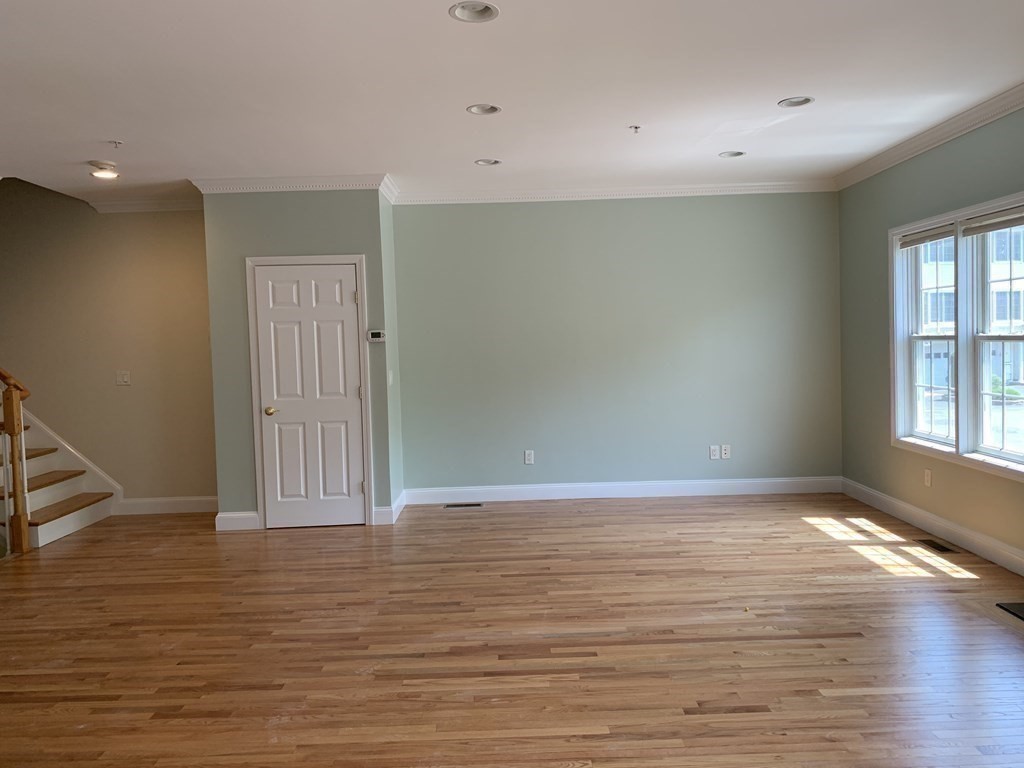 3 Dansereau Place, Unit 3 Middleton, MA 01949 - Photo 9 of 34 a view of an empty room with wooden floor and a window
