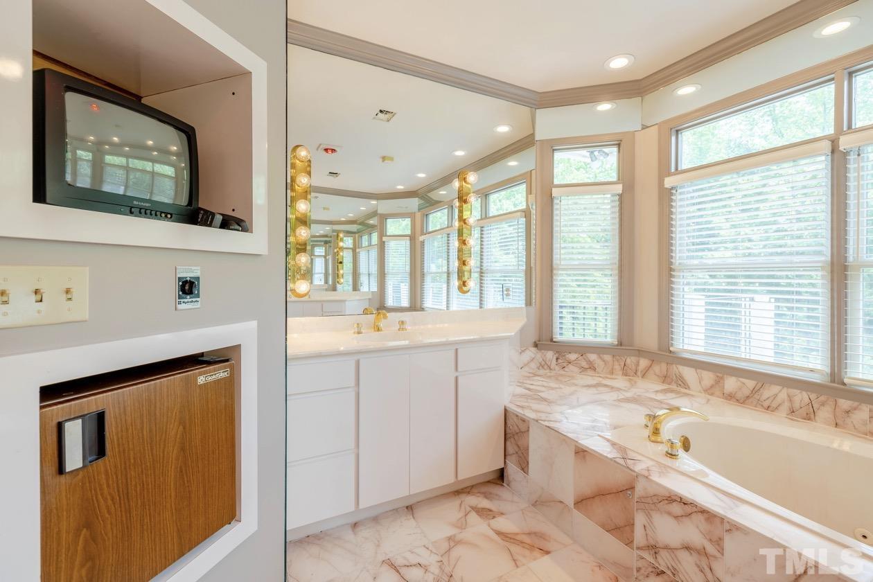 4205 Swarthmore Road Durham, NC 27707 - Photo 14 of 33 a spacious bathroom with a granite countertop tub sink and mirror