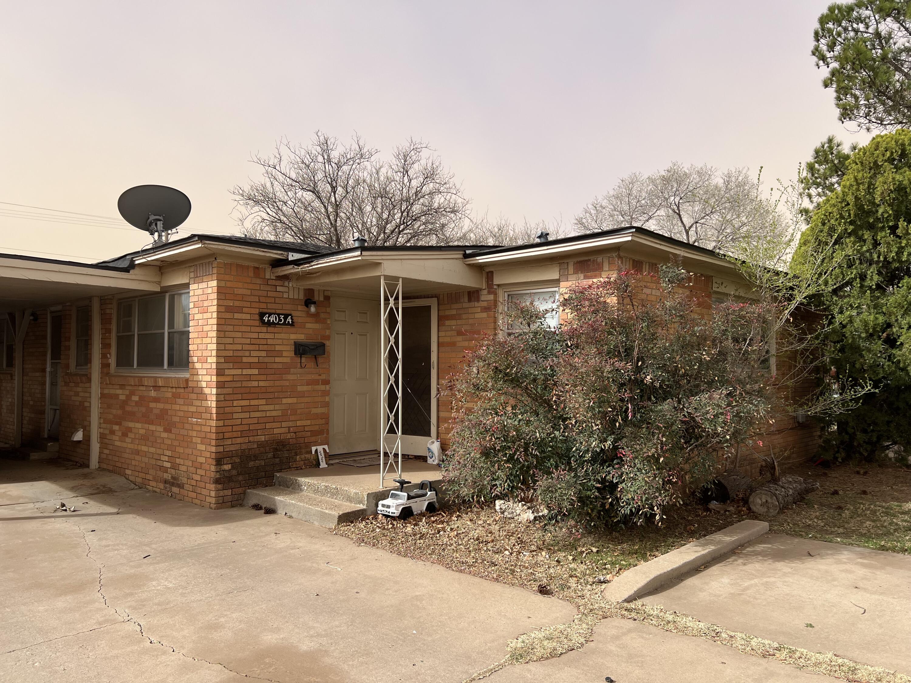4403 31st Street, Unit A Lubbock, TX 79410 - Photo 1 of 11 a view of a house with backyard and trees