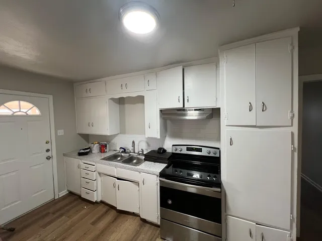 a kitchen with a stove and white cabinets