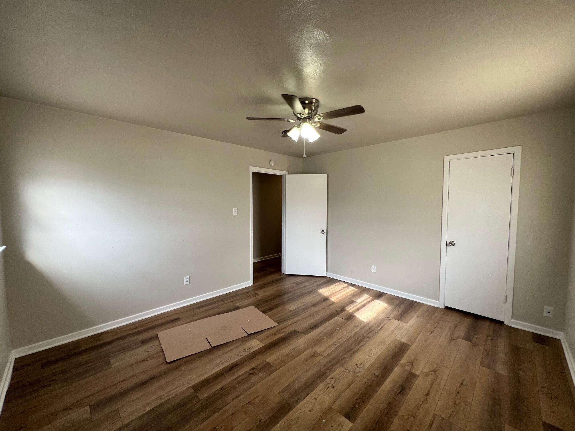 4403 31st Street, Unit A Lubbock, TX 79410 - Photo 7 of 11 wooden floor in an empty room with a window
