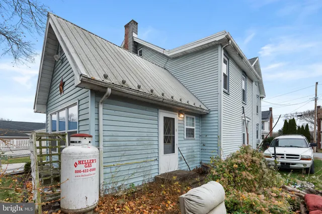 a view of a white house with large windows and a large tree
