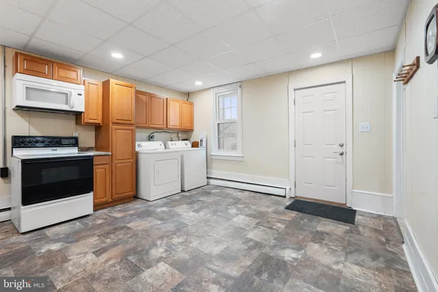 a kitchen with granite countertop a stove a sink and a refrigerator