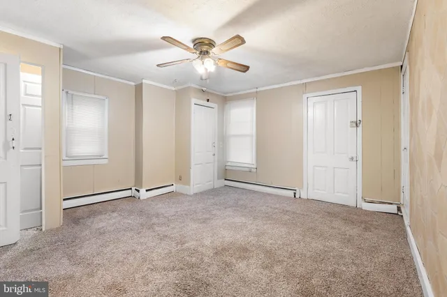 an empty room with closet and fan