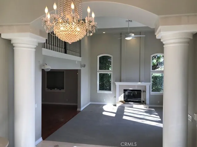 a living room with furniture a fireplace and a chandelier